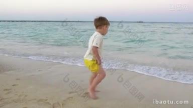斯坦尼康拍摄的一个小男孩站在海边转身回到相机来的浪潮是<strong>洗</strong>他